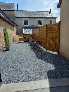 un patio con mesas y sillas y una valla en Appart 3 chambres, en Noyen-sur-Sarthe