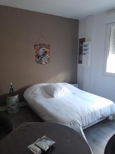 1 dormitorio con cama blanca y mesa en Appart 3 chambres, en Noyen-sur-Sarthe