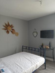 a bedroom with a bed and a table with a tv at Appart 3 chambres in Noyen-sur-Sarthe