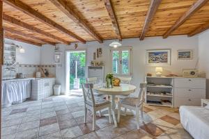een keuken en eetkamer met een tafel en stoelen bij Eco House Zabodarski Beach - Happy Rentals in Čunski