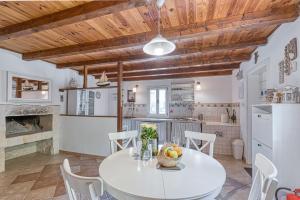 cocina y comedor con mesa blanca y sillas en Eco House Zabodarski Beach - Happy Rentals, en Čunski