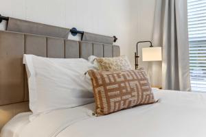 Schlafzimmer mit einem Bett mit weißer Bettwäsche und Kissen in der Unterkunft New River Gorge Retreat 10 min 2 Ace Resort in Oak Hill