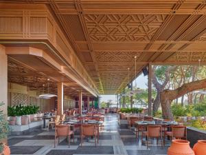 a restaurant with wooden ceilings and tables and chairs at Maxx Royal Kemer Resort in Kemer