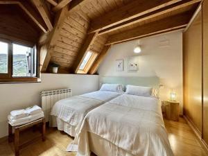 a bedroom with two beds with white sheets and a window at La Glera. En el centro de Sallent de Gállego in Sallent de Gállego
