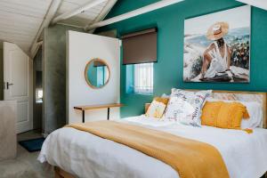 a bedroom with a large bed with a painting on the wall at Casa Rene in Paternoster