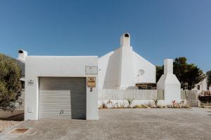 a white house with a garage in front of it at Casa Rene in Paternoster