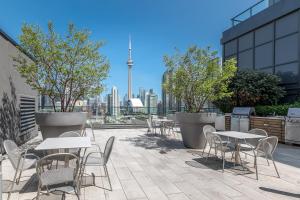 a patio with tables and chairs with a view of the city at Beautiful Condos In the Heart of Downtown by GLOBALSTAY in Toronto