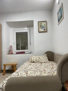 een kleine slaapkamer met een bed en een raam bij Honey Home in Podgorica