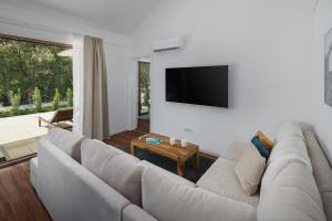 a living room with a couch and a flat screen tv at Luxury Glamping Bay Villas Porto Bus in Bale