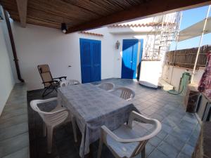 パリヌーロにあるGigia's Houseの青いドア付きのパティオ(テーブル、椅子付)