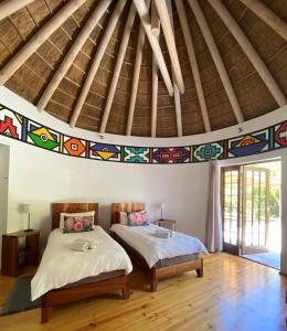 a bedroom with two beds and a ceiling withpired at Badger's Lodge in Knysna