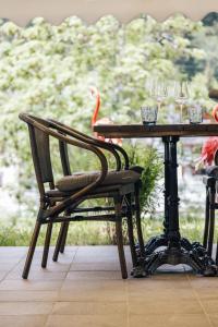 una silla de madera sentada junto a una mesa con copas de vino en DESIGn und FERIEN HOTEL CHRISTANIA, en Fiesch