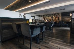 a restaurant with a bar with tables and chairs at DESIGn und FERIEN HOTEL CHRISTANIA in Fiesch