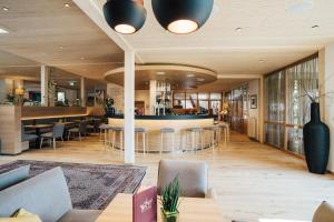 un vestíbulo de un restaurante con mesas y un bar en Hotel SeeRose en Bodensdorf