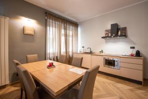 Il comprend une cuisine et une salle à manger avec une table et des chaises en bois. dans l'établissement Top Living Apartments - Casa Valentino, à Turin
