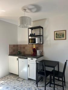 a kitchen with a table and a microwave at THEIA Hotel & Suites - Limoges Centre in Limoges