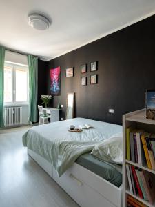 1 dormitorio con 1 cama con pared negra en Cosy flat, en Cormano