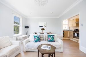 uma sala de estar branca com um sofá e uma mesa em WelcomeStay Colliers Wood Two Bed Apartment - Home Away from Home em Londres