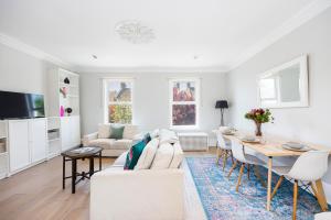 un soggiorno con divano bianco e tavolo di WelcomeStay Colliers Wood Two Bed Apartment - Home Away from Home a Londra