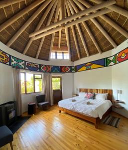 1 dormitorio con 1 cama grande y suelo de madera en Badger's Lodge, en Knysna