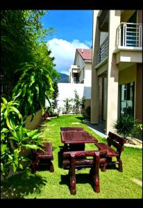 a picnic table and benches in front of a building at IMPIAN STAY #1 #15pax Semi Bungalow House半独立別墅 in Kuah