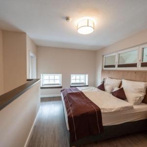 a bedroom with a large bed in a room with windows at Ferienwohnung "Landhaus Buchenallee" in Bad Bentheim