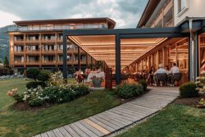 a building with people sitting at tables on a patio at Hotel SeeRose in Bodensdorf