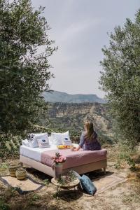 a woman sitting on a bed in a field at Star Sleep Kalesia Heraklion in Heraklio Town