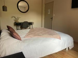 a bedroom with a bed with a mirror and a table at La renaissance in Saint-Cirgues-en-Montagne