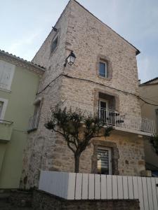 a large brick building with a tree in front of it at la placette in Hérépian