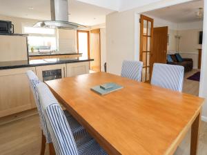 a kitchen with a wooden table and chairs at 11 Overdale Avenue in Wirral