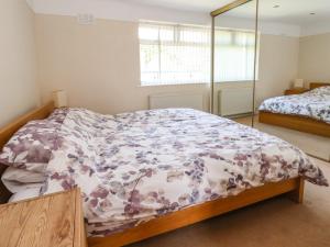 a bedroom with a bed with a floral comforter at 11 Overdale Avenue in Wirral