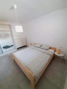a bedroom with a bed in a white room at Green Bee Apartment in Lesce