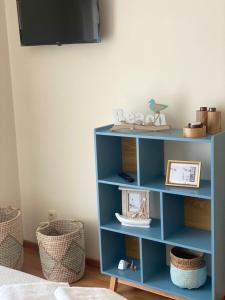 ナザレにあるNazare Marのテレビ付きの客室内の青い本棚