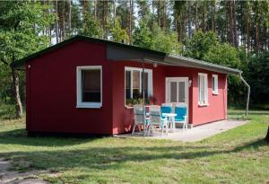 una casa roja con sillas y una mesa. en F-1108 Häuser Prosnitz Haus16 Terrasse, Gartennutzung, en Gustow