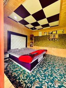 Schlafzimmer mit einem großen Bett und einem roten Kissen in der Unterkunft Sheen Homestay in Gulmarg