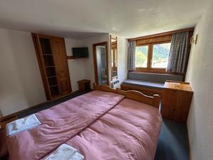 ein Schlafzimmer mit einem Bett und einem großen Fenster in der Unterkunft Les Bouquetins in Zinal