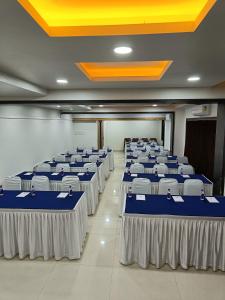 uma fila de mesas numa sala com azul e branco em Rapid Lakme Executive Hotel em Pune