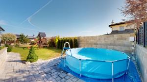 una piscina en un patio trasero con bañera azul en Dom v raji, en Spišské Tomášovce