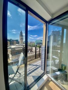 einen Balkon mit Blick auf einen Uhrturm in der Unterkunft Amazing City Centre 1 bedroom Apartment with Balcony LGBTQ Friendly in Belfast