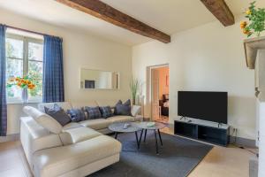 a living room with a couch and a flat screen tv at Tuscan Skye - Villa Sofia with private swimming pool and garden in Barga