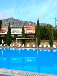 a large swimming pool in front of a building at Thalassa Hotel in Paleros