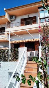 een huis met een trap naar een balkon met een stoel bij Santa Polita in Santa Pola