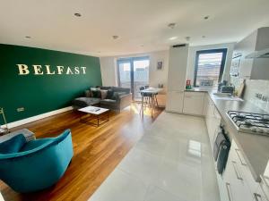 eine Küche und ein Wohnzimmer mit einer grünen Wand in der Unterkunft Amazing City Centre 1 bedroom Apartment with Balcony LGBTQ Friendly in Belfast