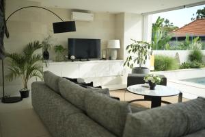 a living room with a couch and a tv at VILLA CELAVI 15 in Kerobokan