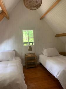 a bedroom with two beds and a window at Fermette La bergerie in Cormont