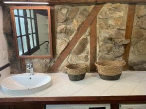 a bathroom with a sink and a mirror at Fermette La bergerie in Cormont