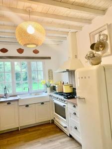 a kitchen with a white refrigerator and a stove at Fermette La bergerie in Cormont