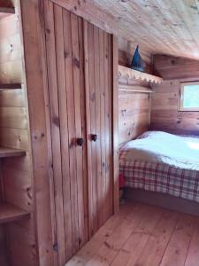 a bedroom with a bed in a wooden cabin at Chalet 1 chambre in Chenecey-Buillon