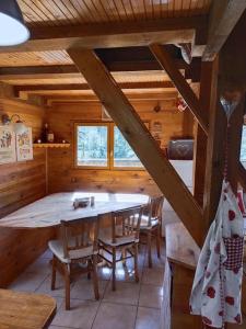 a dining room with a table and chairs in a cabin at Chalet 1 chambre in Chenecey-Buillon